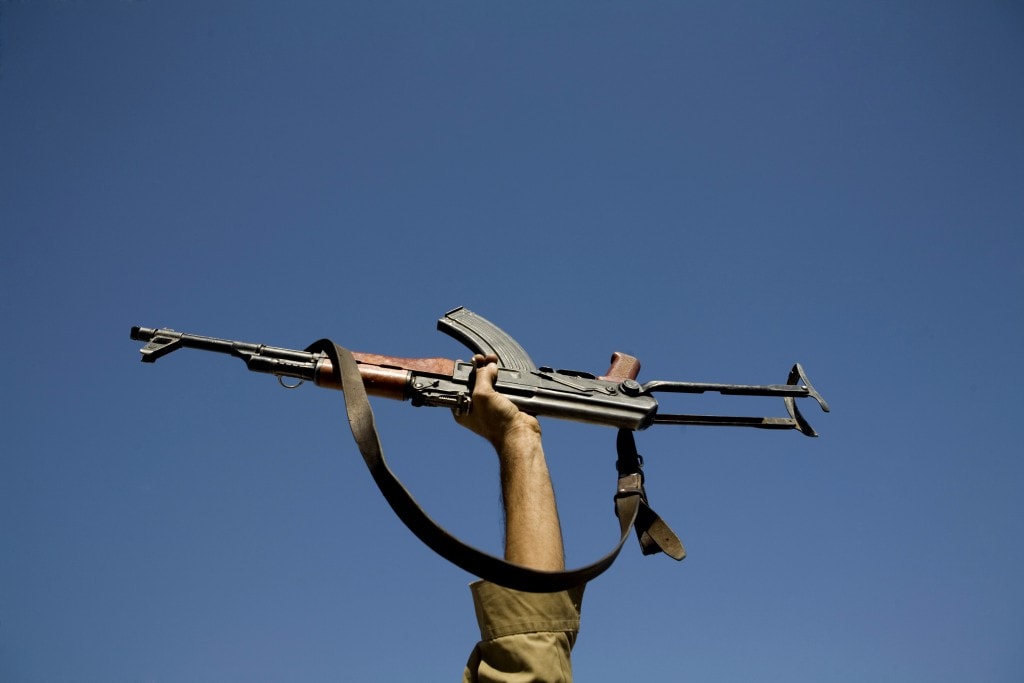 An actor holds up his gun during filming of an Iranian film directed by Sadegh Karamyar about the Iran-Iraq war (1980-88) on a film set about 25km (15 miles) south of Tehran September 25, 2007. REUTERS/Morteza Nikoubazl (IRAN) - RTR1U9JK